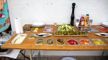 Die klappbare Theke ist nach dem Zusammenklappen 6,5 cm flach. Bei uns verschwindet sie bis zum nächsten Event hinter der Grillstation an der Wand. Theke klappbar mit GN-Behälter
